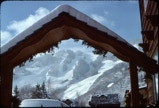 Peaked entrance shelter frames snow covered peaks.
