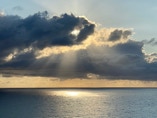 The hand of God, a cloud, illuminates the Atlantic.